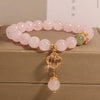 Pink crystal beaded bracelet with a gold-tone four leaf clover charm