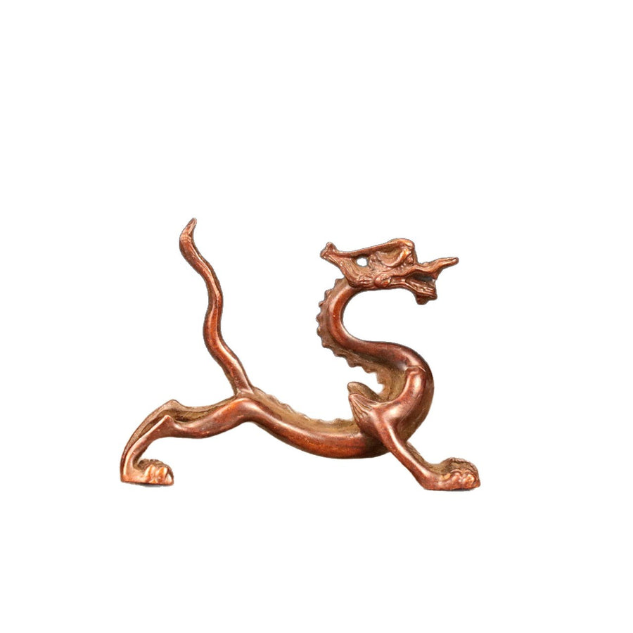 Antique brass dragon figurine serving as a pen holder on a white background