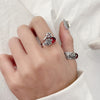 Hand wearing a vintage silver ring with a red stone and Pixiu design