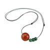 Close up of a red agate bead necklace with three green beads on a black leather cord