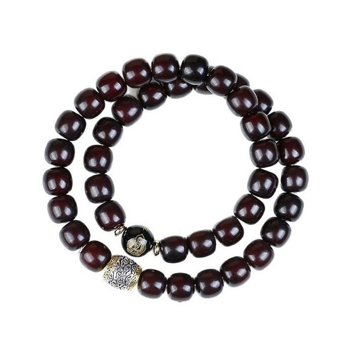 Double wrap dark brown bodhi seed bracelet with silver accent beads on white background