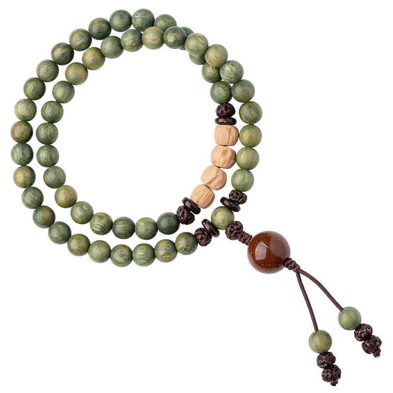 Close-up of a green sandalwood wood bracelet wrapped around a wrist with brown cord knots
