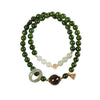 Close up of a double strand green jade bracelet with a lotus pod charm on a wrist