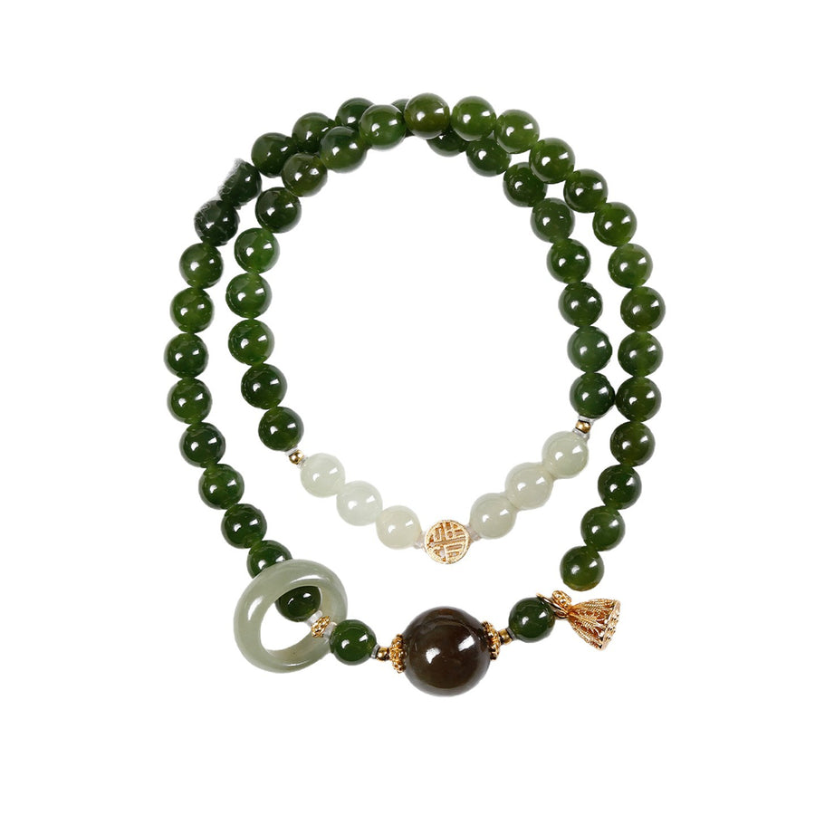 Close up of a double strand green jade bracelet with a lotus pod charm on a wrist