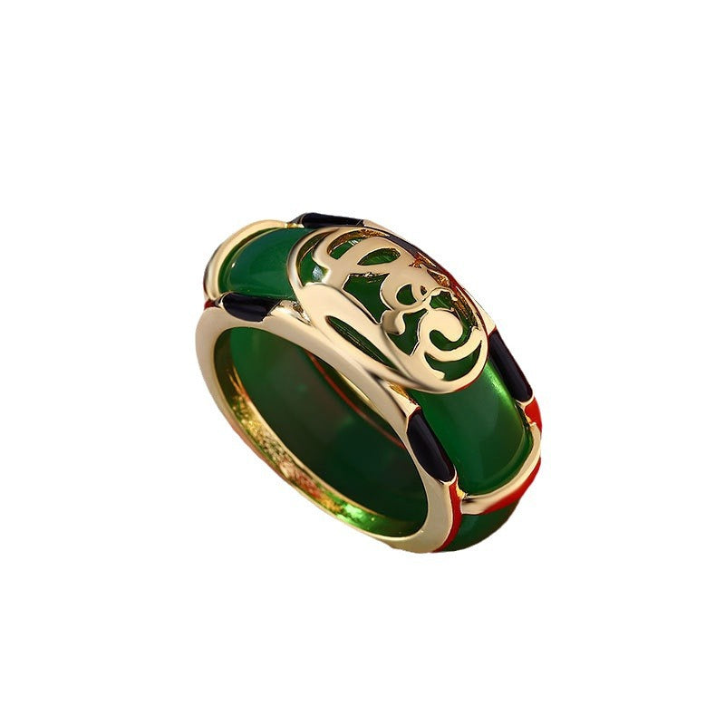 Close up view of a green jade ring with a gold plated cloud design on a red background