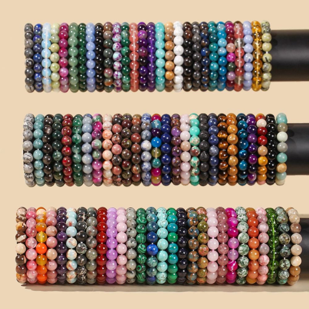 A collection of colorful natural stone beaded bracelets arranged on black display rods.