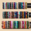 A collection of colorful natural stone beaded bracelets arranged on black display rods.