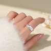 Close up of a silver hammered texture ring on a finger