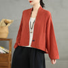 Woman wearing a rust colored cotton linen kimono jacket with pockets