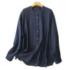 Back view of a white long sleeve cotton shirt hanging on a wooden hanger