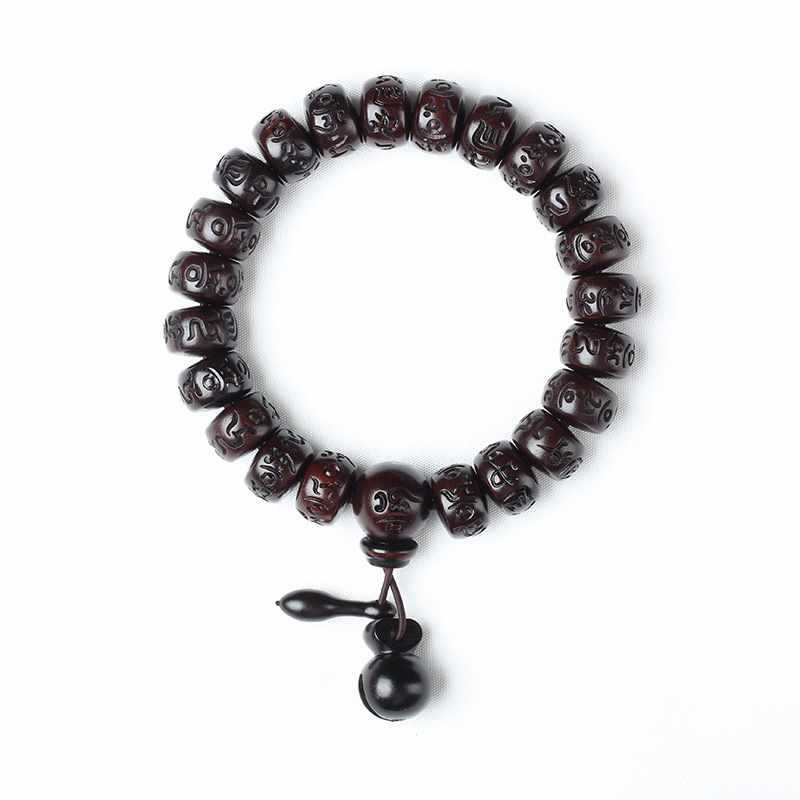 Dark carved wood bracelet with mantra beads and gourd charm on white background