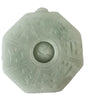 Close up of a light green octagonal jade pendant with a Bagua pattern and Yin Yang center