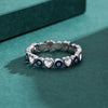 Close up of a woman's hand wearing a silver ring with blue evil eyes and hearts