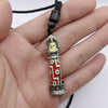 Close-up of a red and white nine-eye Dzi bead pendant with a gold Buddha figure on top