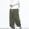 Man wearing loose fitting olive green corduroy pants with a white drawstring waist