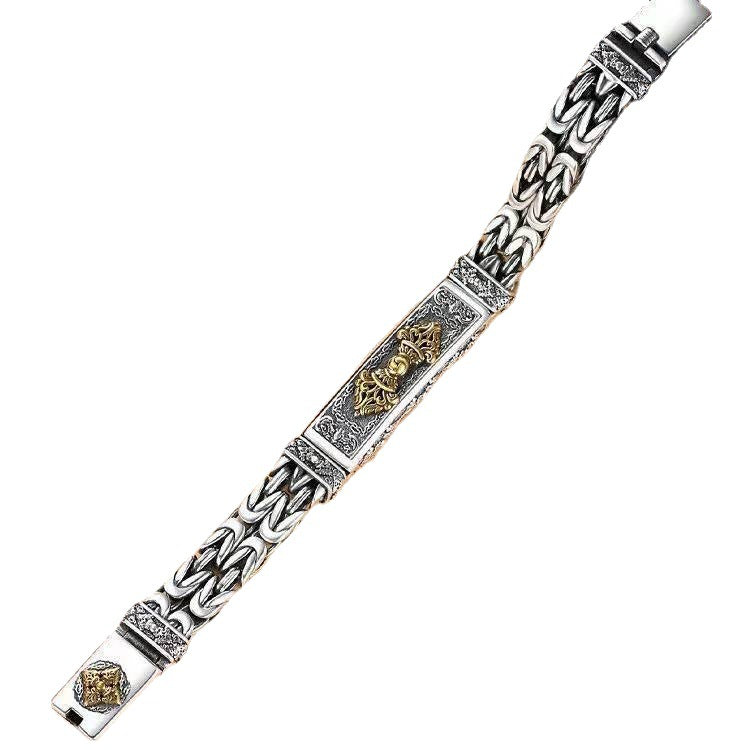 Silver-tone twisted braided bracelet with gold-tone Vajra center charm on white background