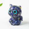 Small blue lapis lazuli crystal chip resin cat figurine sitting on a white surface