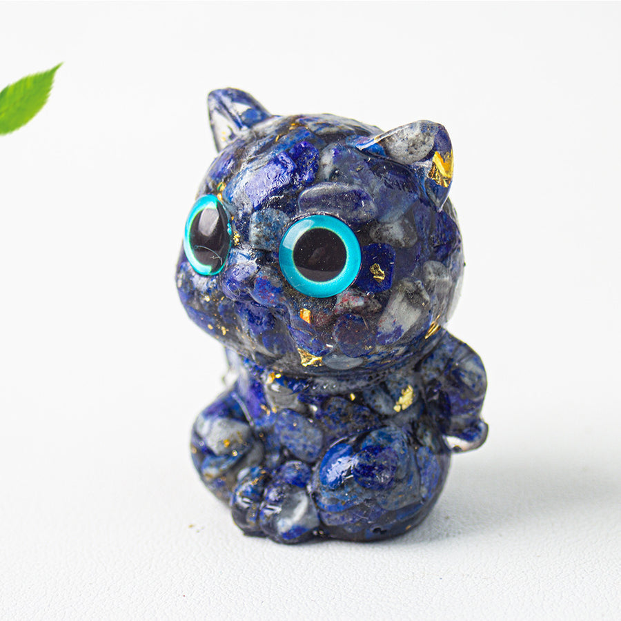 Small blue lapis lazuli crystal chip resin cat figurine sitting on a white surface