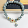 Light green optimized jade beaded bracelet with white flower charm