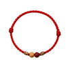 Braided red cord bracelet with peach wood beads