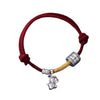 Close up of a red knotted bracelet with a silver horse charm and bead