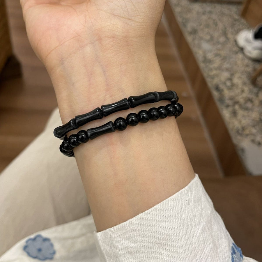 Black bamboo joint and round bead stretch bracelet on wrist