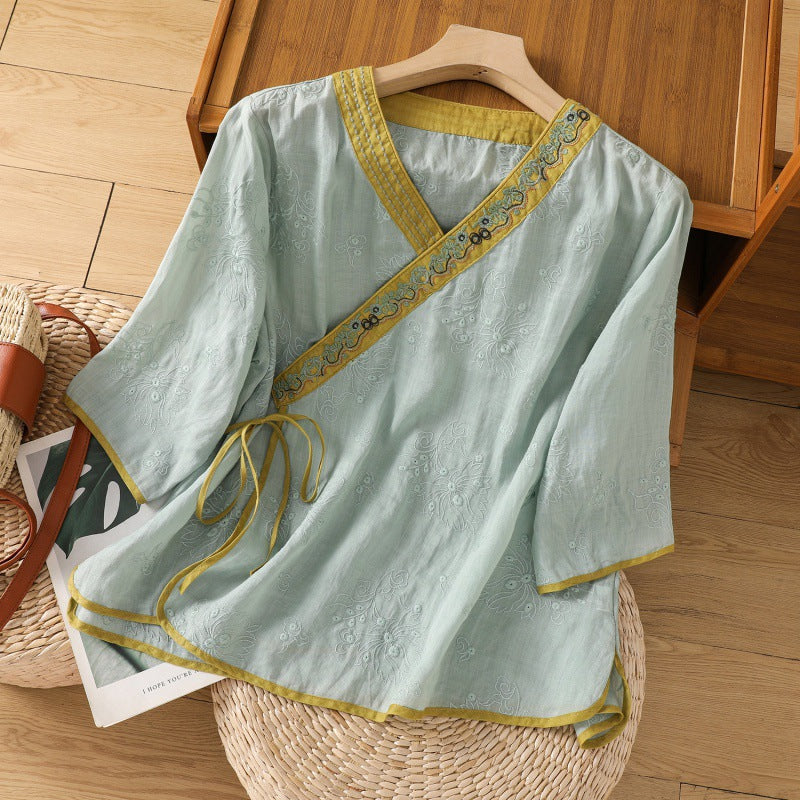 Light green embroidered cotton linen top on a wooden hanger