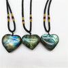 Three heart shaped labradorite pendants on black cords with gold beads