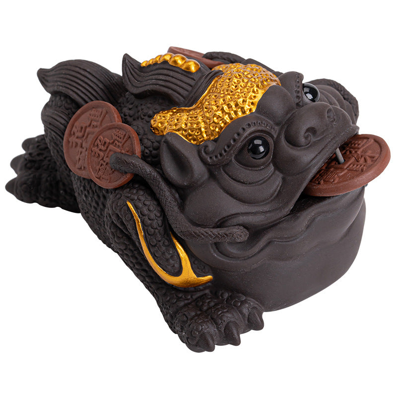 Purple clay money toad tea pet with gold accents and coins on a wooden tea tray