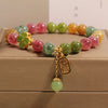 Colorful tourmaline beaded bracelet with a gold-tone four-leaf clover and pendant charm.