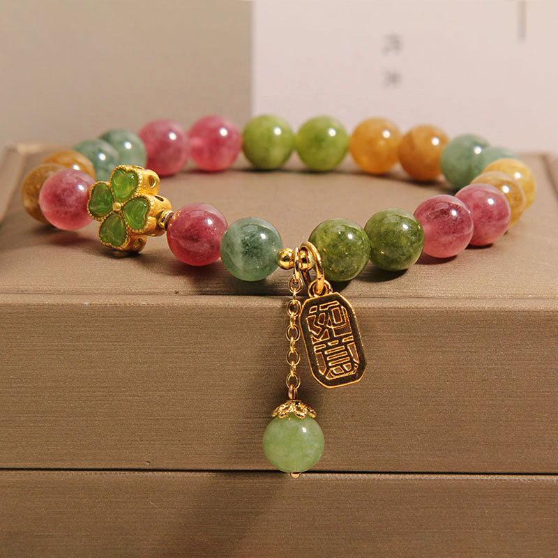 Colorful tourmaline beaded bracelet with a gold-tone four-leaf clover and pendant charm.