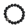 Close up of a black lava rock bracelet with one silver fish scale bead on a wrist