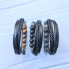 Three variations of a black leather bracelet with different stone beads lying on a white surface