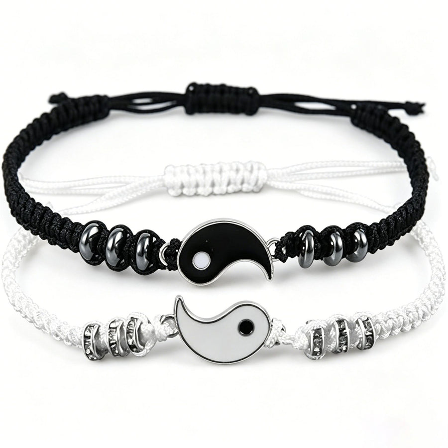 Two woven cord bracelets with Yin Yang charms, one black and one white