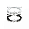 Black and white beaded bracelets with silver Pixiu charms on a white background