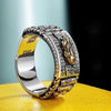 Close up of a silver and gold metal ring with a Pixiu head and prayer wheel details