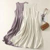 Two sleeveless midi dresses in purple and beige laid flat on a neutral background