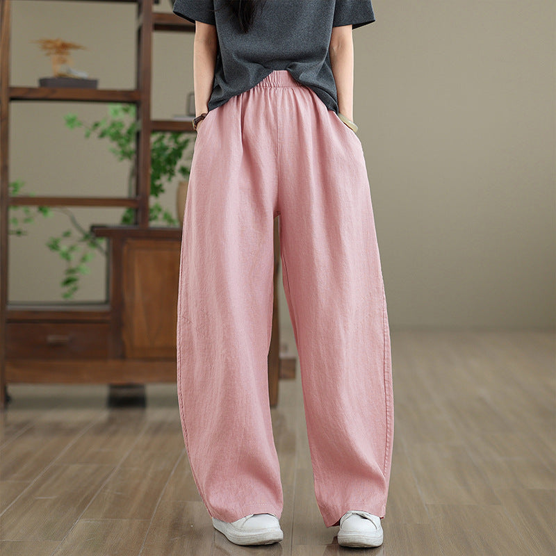 Model wearing loose fitting pink wide leg linen pants with hands in pockets