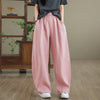 Model wearing loose fitting pink wide leg linen pants with hands in pockets