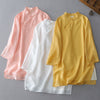 Three folded shirts in pink, white, and yellow showing the double layer hem and frog buttons