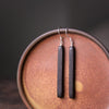Pair of long, rectangular black wood dangle earrings on silver hooks