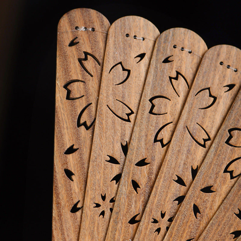 Close up of carved wooden fan ribs showing openwork floral patterns