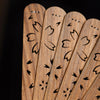 Close up of carved wooden fan ribs showing openwork floral patterns