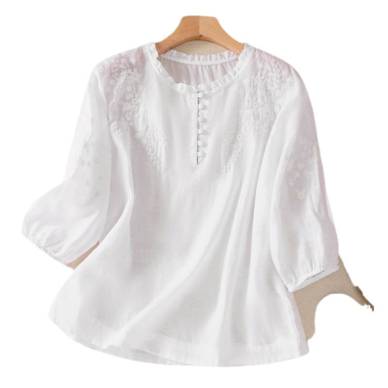 White women's cotton linen shirt with floral embroidery and half puff sleeves on a hanger