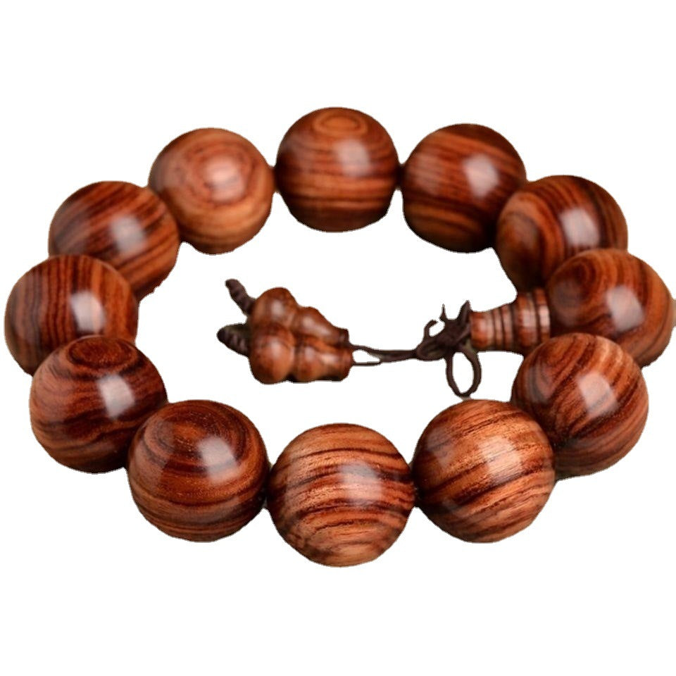 A close-up of a polished black rosewood bracelet with large round beads and a gourd charm.