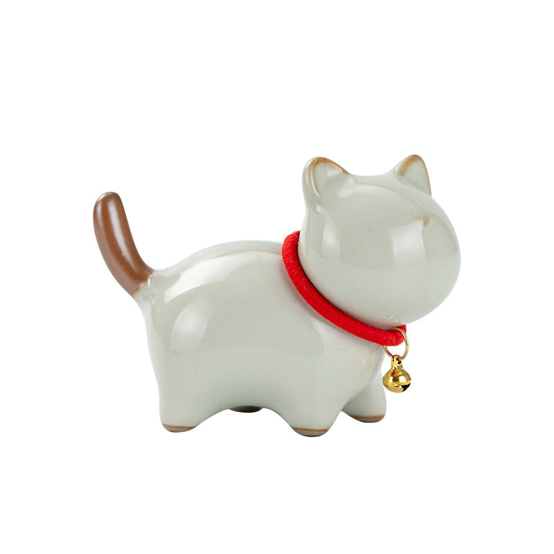 Small standing ceramic cat figurine with a red collar and gold bell