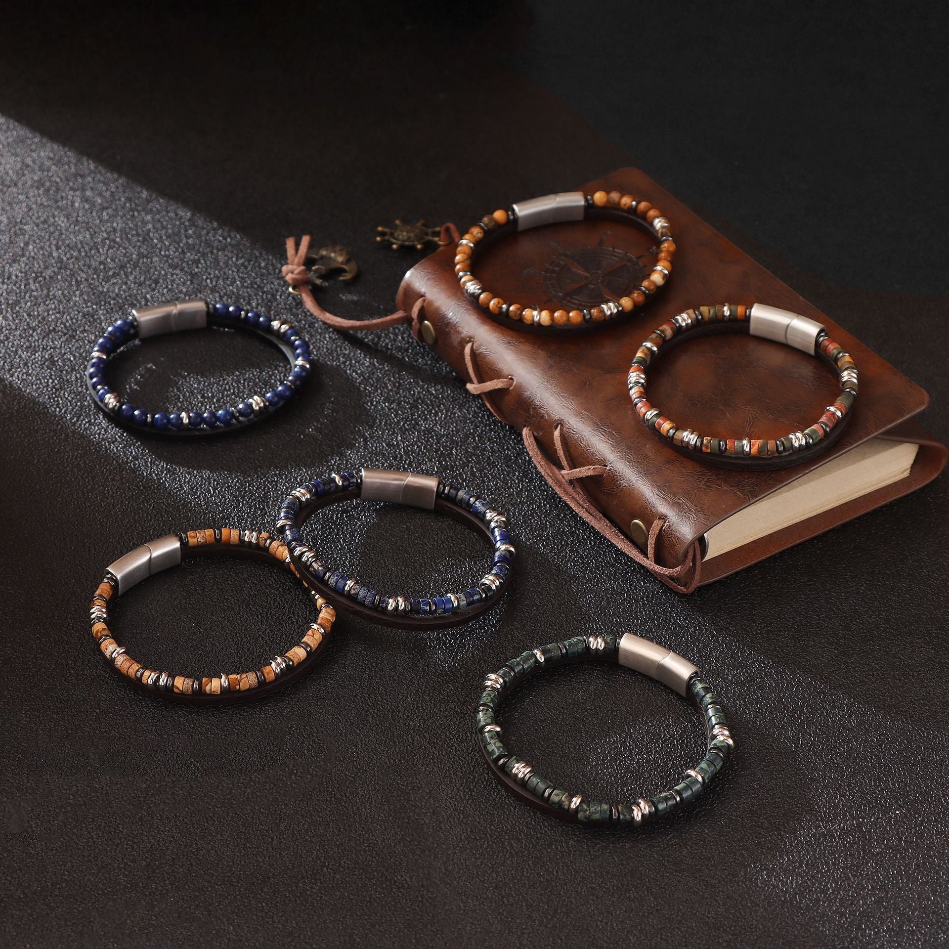 Double wrap bracelet with blue Lapis Lazuli beads and silver-tone accents resting on a brown leather journal.