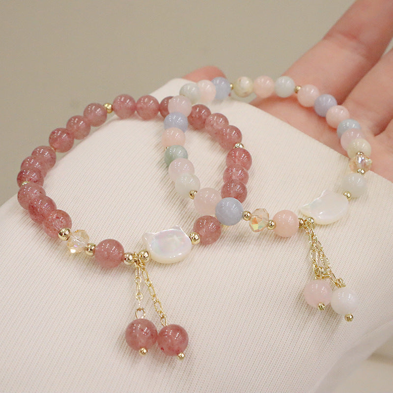 Pink strawberry quartz beaded bracelet with a white shell cat charm and dangling beads