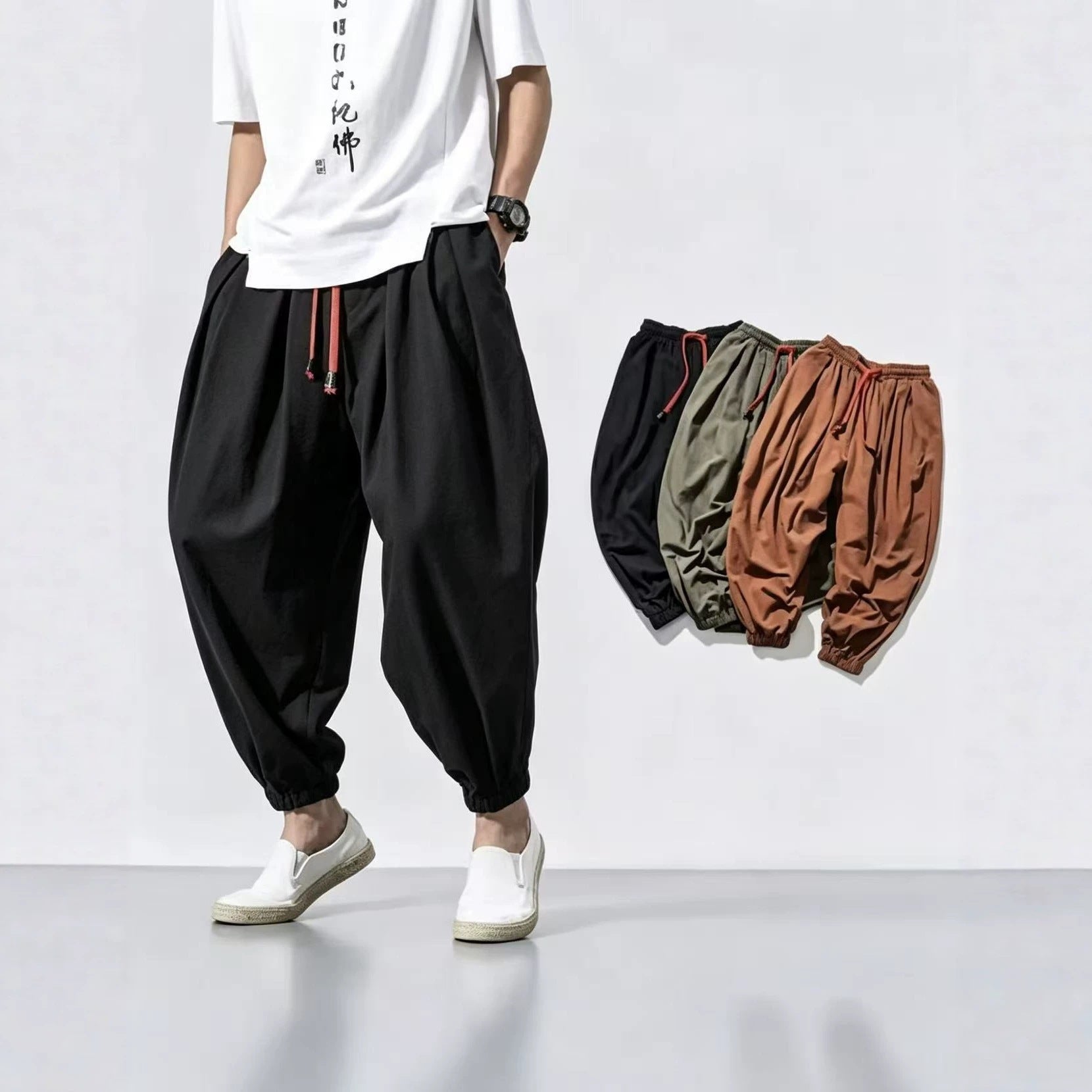 Model wearing black loose-fit linen harem pants with red drawstring