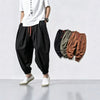 Model wearing black loose-fit linen harem pants with red drawstring